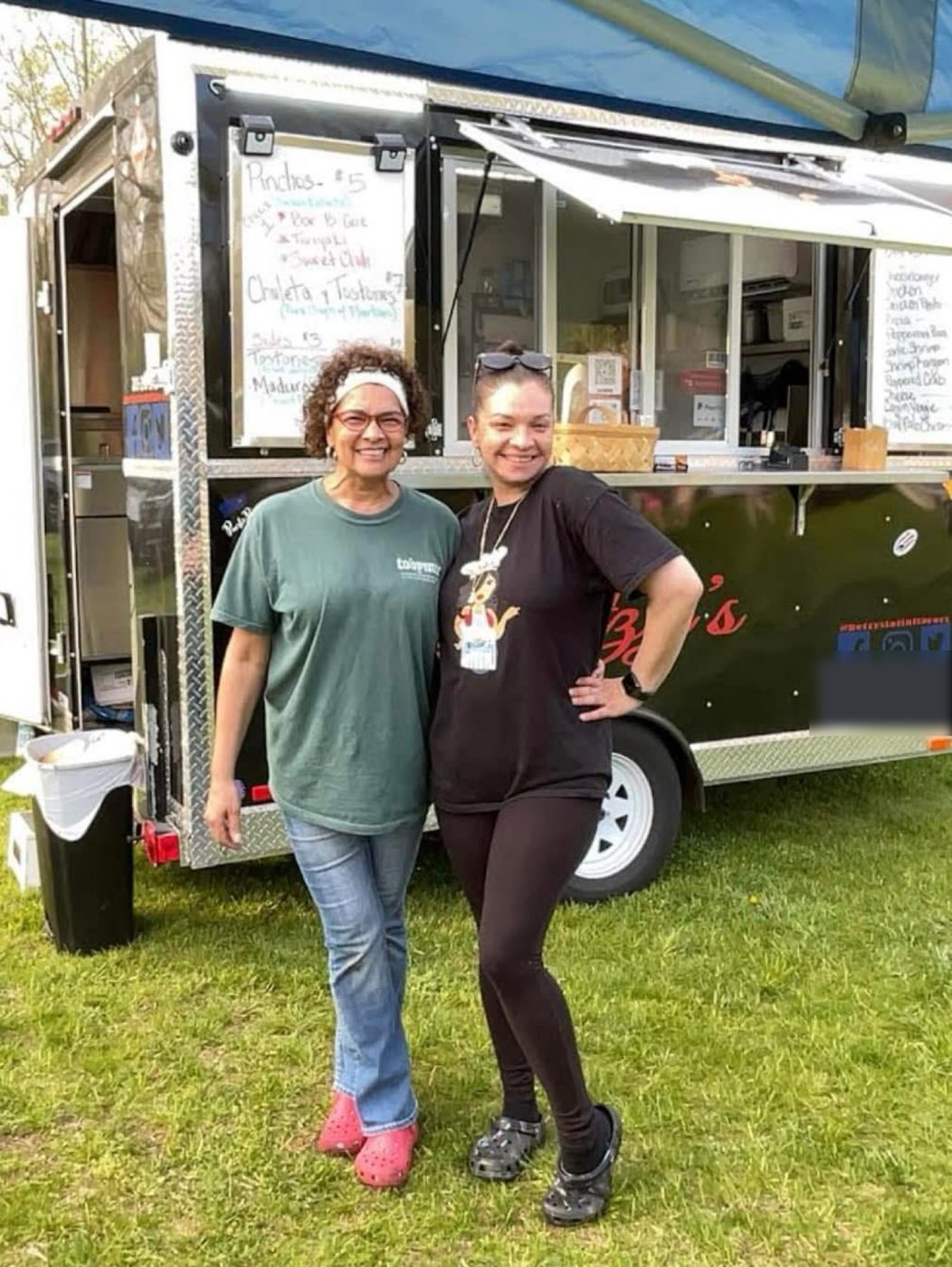 Betzy and a friend smiling in front of the food trailer