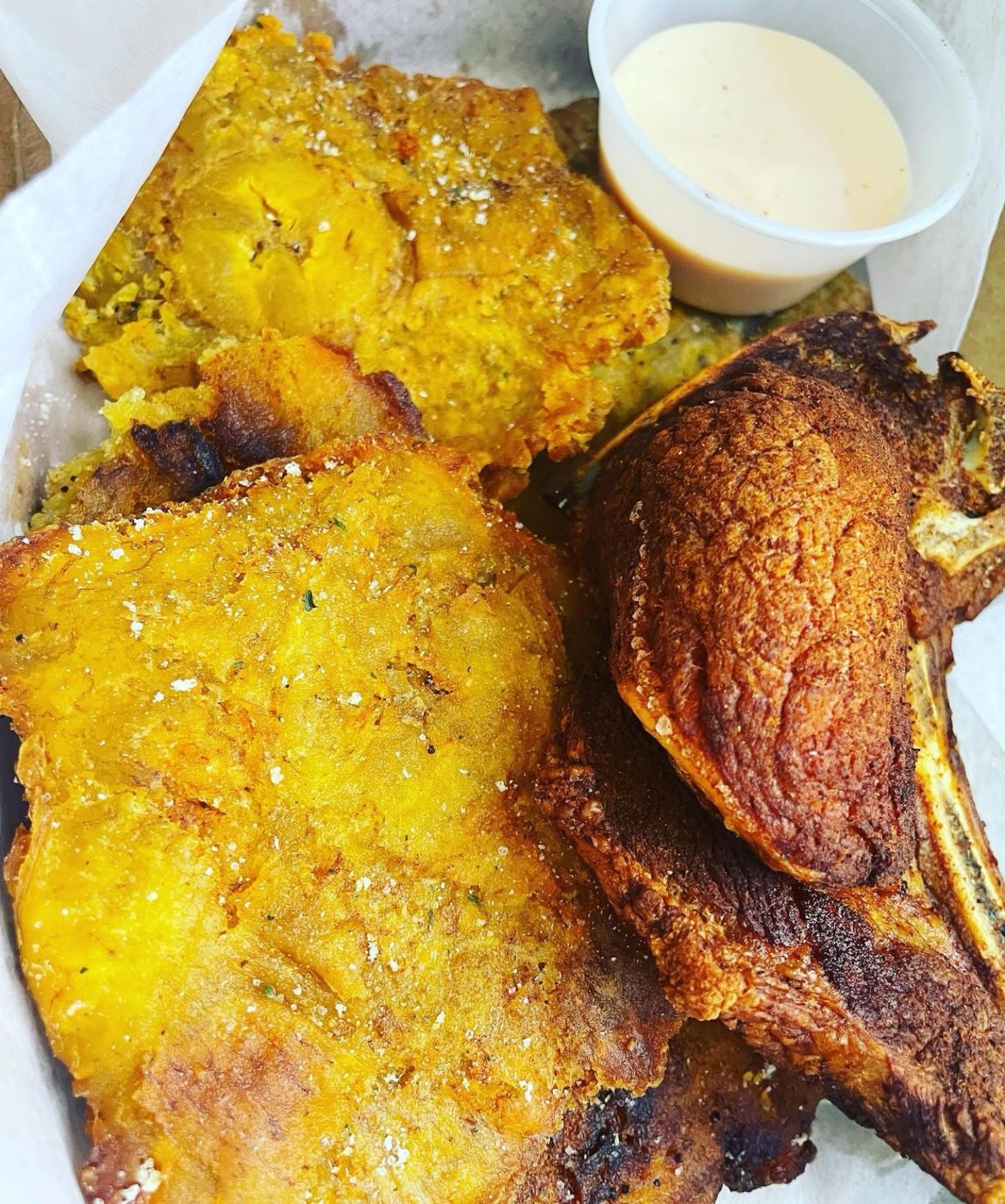 Tostones with a fried pork chop and dipping sauce